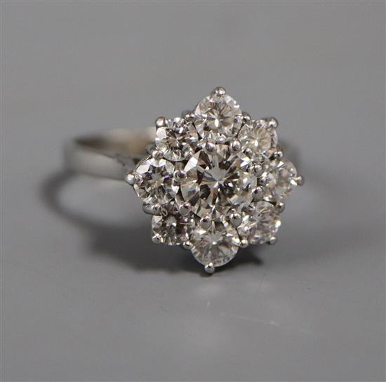 A modern 18ct white gold and nine stone diamond cluster ring, size M.